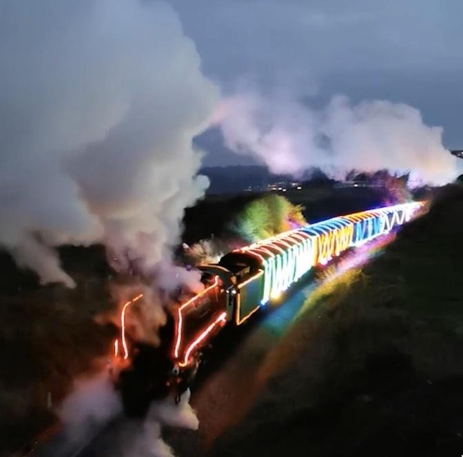 Watch this train covered in CHRISTMAS LIGHTS wind through UK village