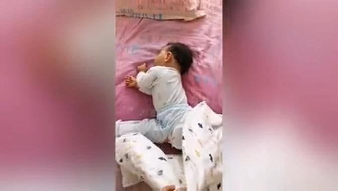 Toddler seen doing splits while sleeping in bed